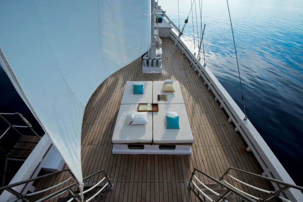 White daybeds arranged on the deck aboard Alexa