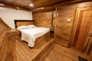 Gili Room on the lower deck of Alfathran 3 with queen bed and timber walls