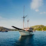 Aerial view of Alfathran 3 phinisi at anchor among the Komodo islands