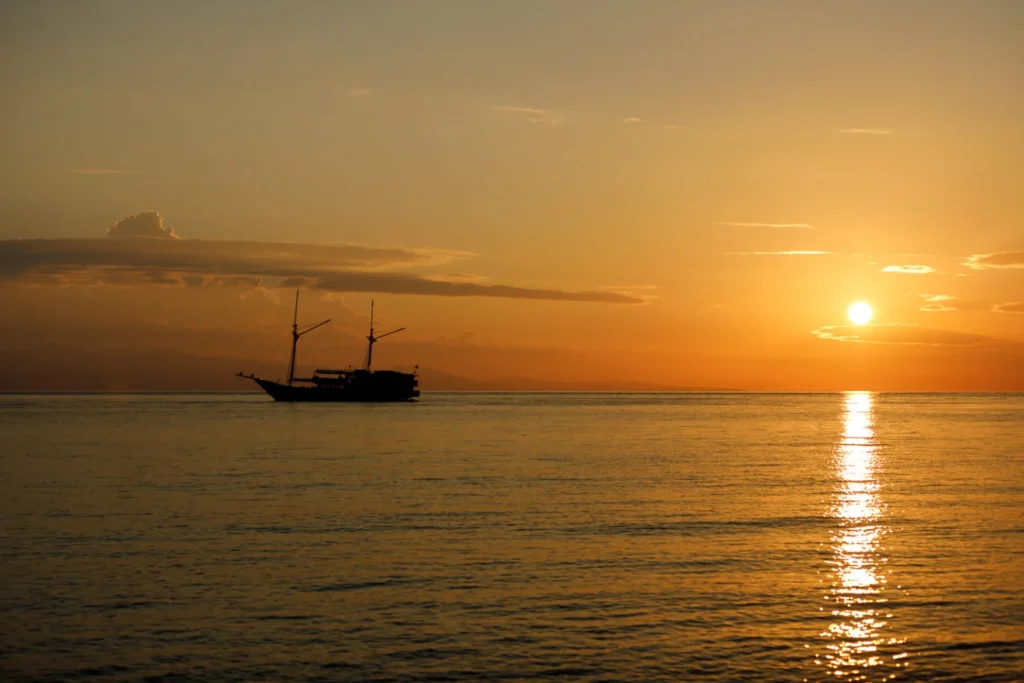 Aliikai Voyage silhouetted against an Indonesian sunset