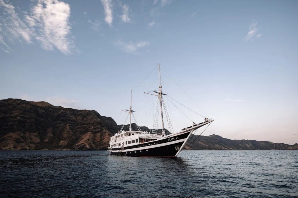 Aliikai Voyage phinisi at anchor beside an Indonesian island