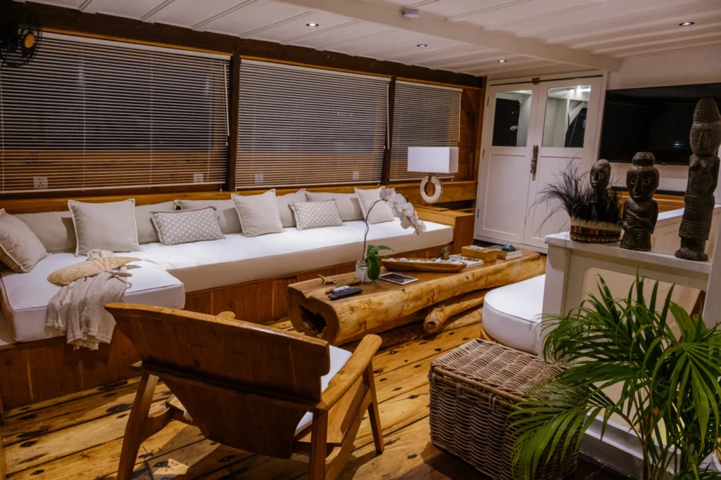 Interior lounge with wrap-around windows aboard Aliikai Voyage