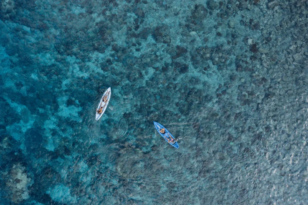 Aerial view of guests kayaking and paddleboarding near Aliikai Voyage