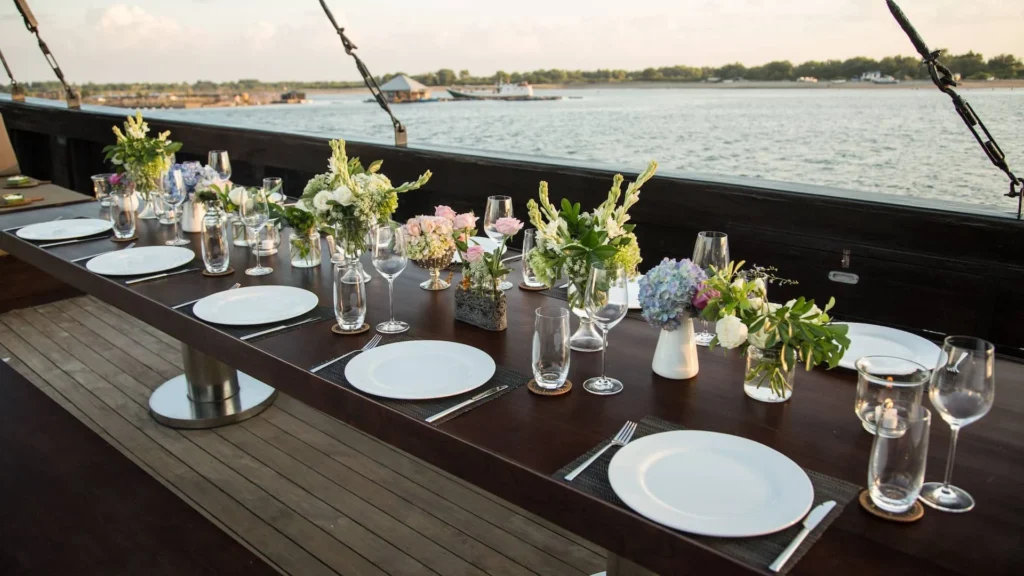 Alfresco dining table set with flowers aboard Alila Purnama