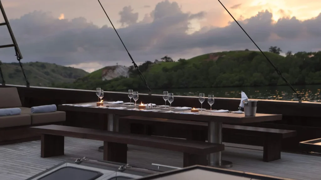 Long dining table set for an event on the deck of Alila Purnama