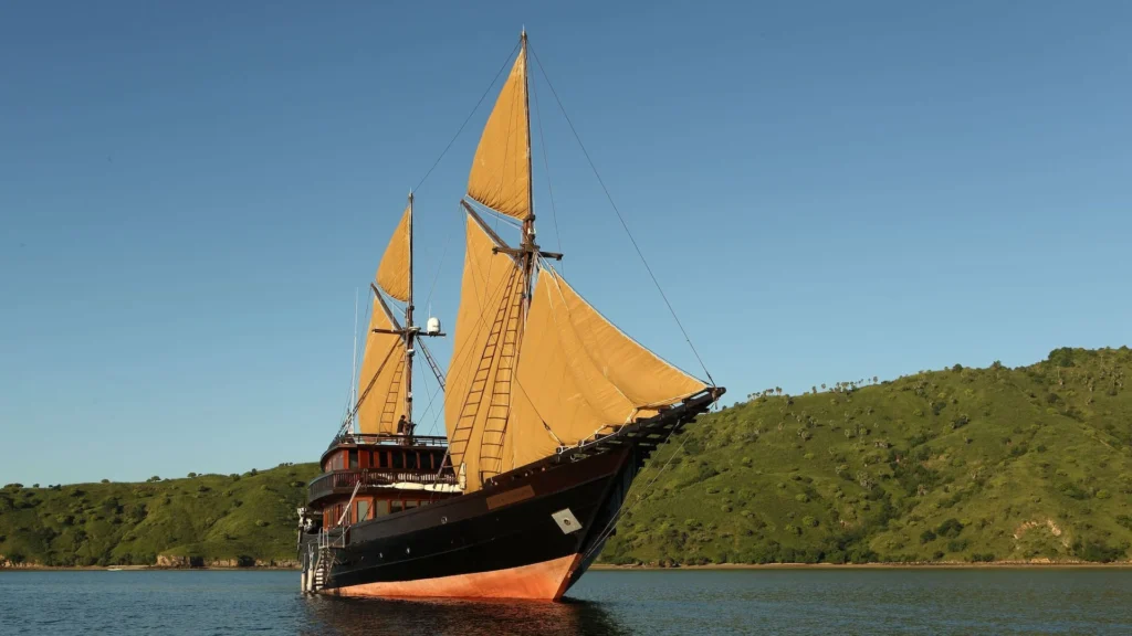 Alila Purnama phinisi sailing past green Indonesian islands