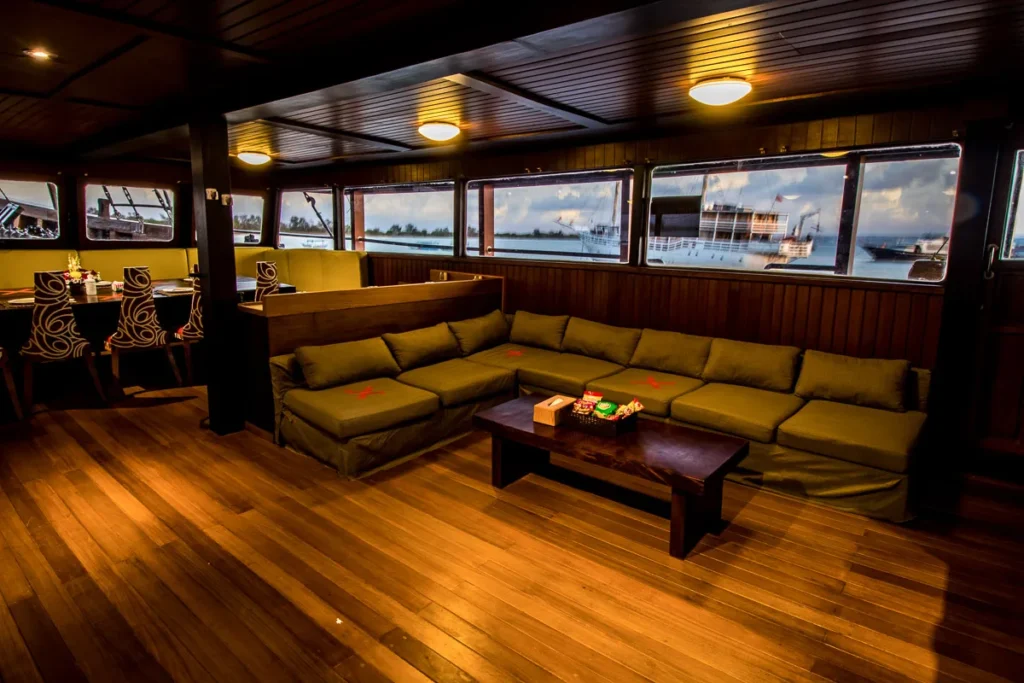 Indoor lounge of Cheng Ho with a yellow corner sofa, coffee table and wooden floor