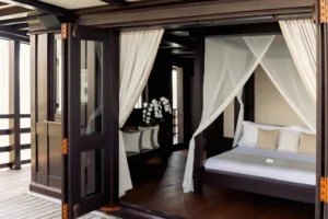 Master suite with a four-poster bed aboard Dunia Baru