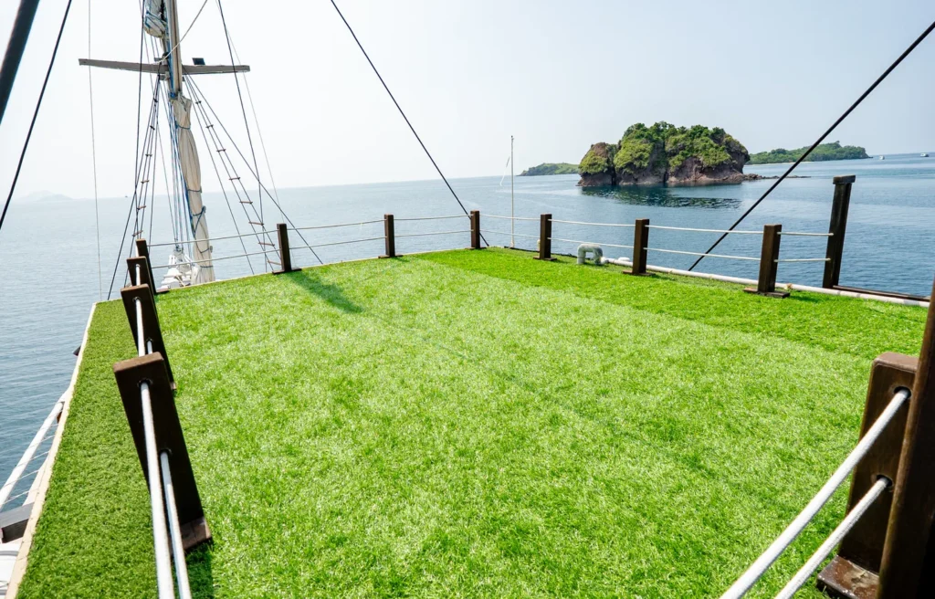 Open rooftop deck with artificial grass aboard Ikan Kayu