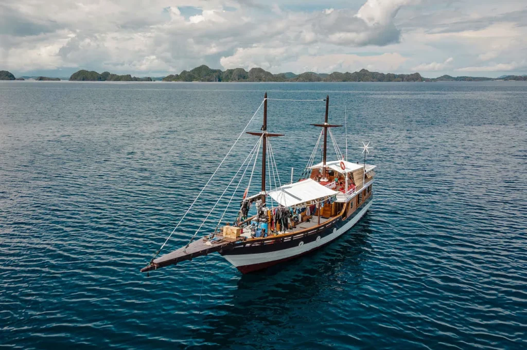 Kira Kira phinisi seen from the water with both masts rigged
