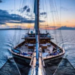Lamima phinisi under sail at sunset