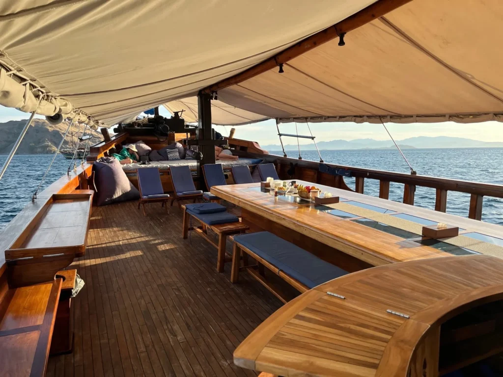 Long outdoor dining table on the main deck of Moana Cruising