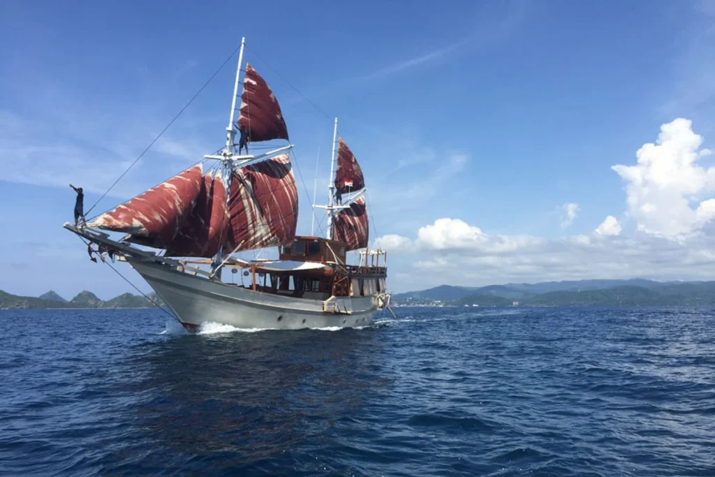 Nyaman phinisi cruising under sail in Komodo