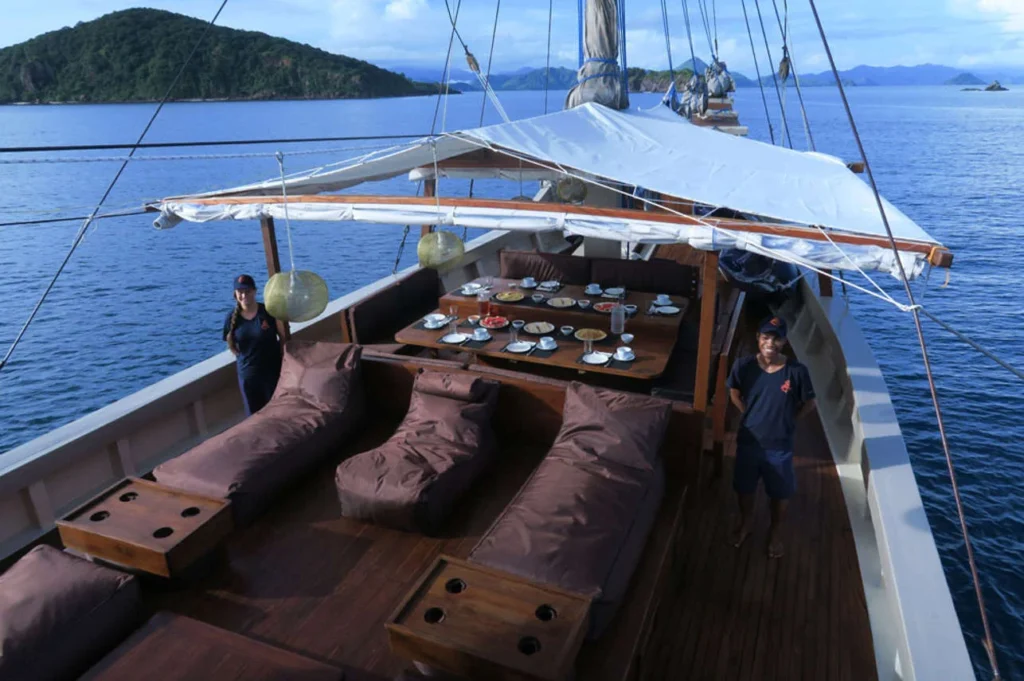 Sun deck seating and dining table aboard Nyaman
