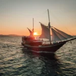Queenesia II Buginese phinisi under sail at sunset