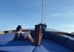 Tourist relaxing on a comfortable boat deck while cruising between islands on a fast-paced Komodo one day tour