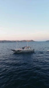 Semesta Voyages cruising across calm open sea with islands on the horizon