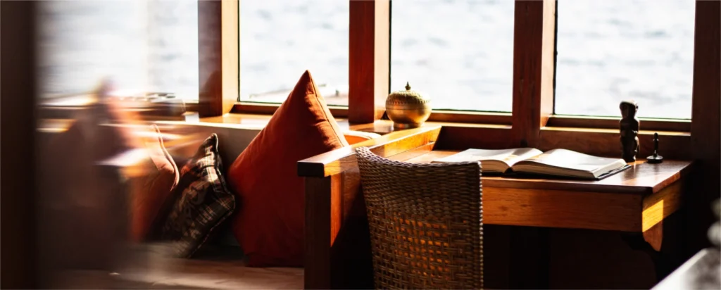 Shaded outdoor lounge seating and writing desk aboard Si Datu Bua