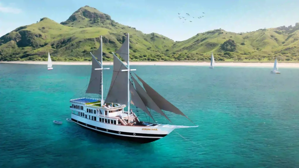Drone view of Sukha Sail 2 phinisi under sail with island headlands behind