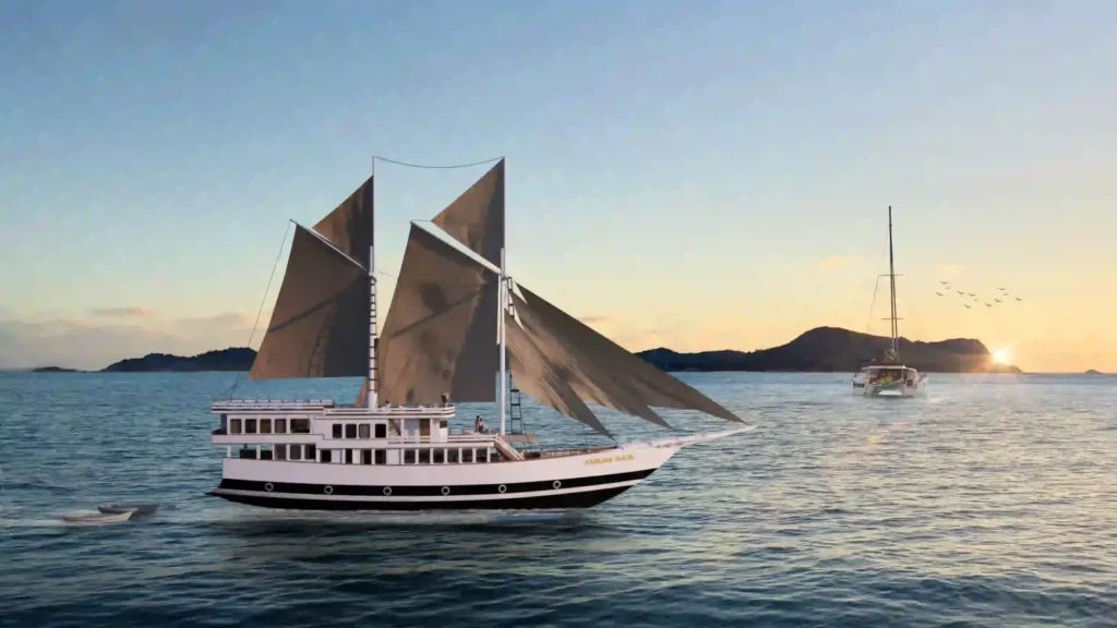 Sukha Sail 2 phinisi under full sail at sunset off the Komodo islands