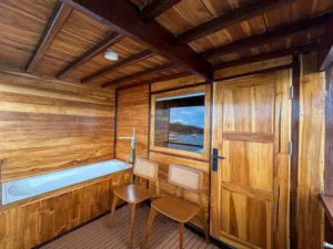 Bed and sea-view window in the Master Cabin of Sundari Voyages