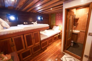 Beds and storage in a twin suite aboard Tambora