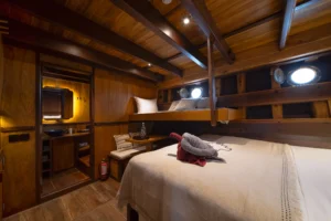 Ta’Talasa Asmat Cabin queen bed, desk and portholes