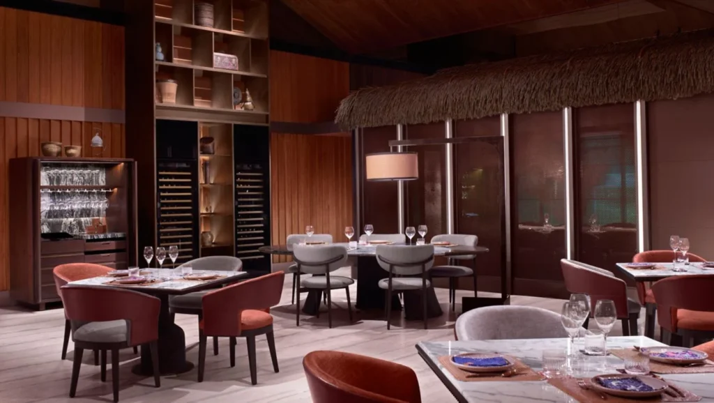 Round dining tables and upholstered chairs in the warmly lit Umasa dining room