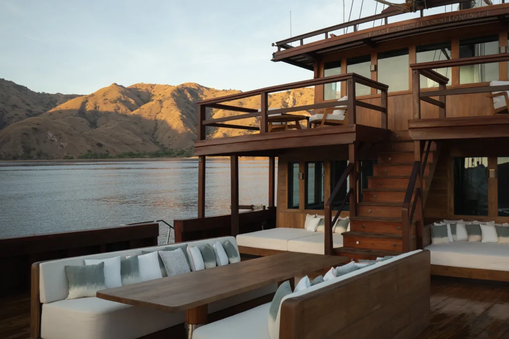 Wide outdoor guest lounge on the main deck of Vela