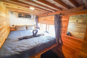 Signature cabin aboard Yukai phinisi with queen bed and ocean-view windows