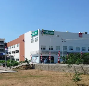 Siloam Hospitals Labuan Bajo building with green signage seen from the road