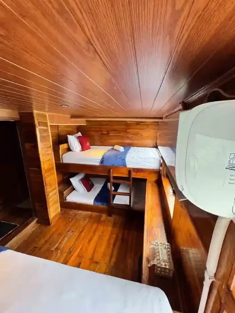 Wooden bunk beds with white bedding in an Aimar Cruise sharing cabin