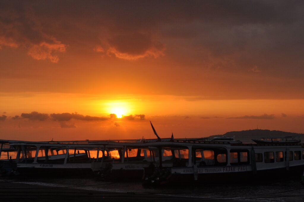 Public boats moored at Bangsal Harbour in Lombok near sunset