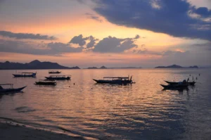 Colourful sky over anchored boats at sunset in Labuan Bajo bay