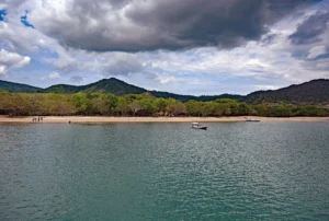 A quiet beach and calm sea under heavy grey clouds in the Komodo region