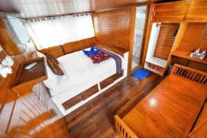Master cabin bed, desk and timber floor aboard Lady Denok