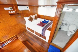 Master cabin bed beside the ensuite bathroom aboard Lady Denok