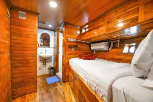 Single cabin bed beside the ensuite doorway aboard Lady Denok