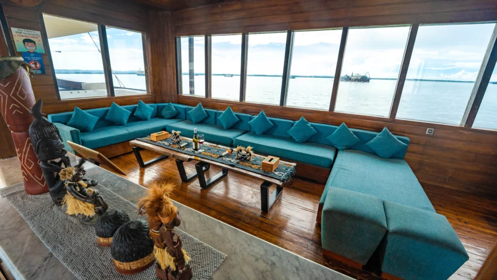 Indoor lounge with teal sofas and sea views aboard Neomi Cruise