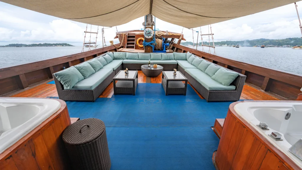Covered outdoor lounge with teal sofas on the middle deck of Neomi Cruise