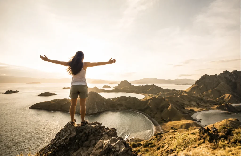 Traveller overlooking the three bays of Padar Island at sunrise in Komodo National Park