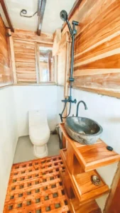 Wood panelled ensuite bathroom with shower and stone basin aboard Papiton Duwa