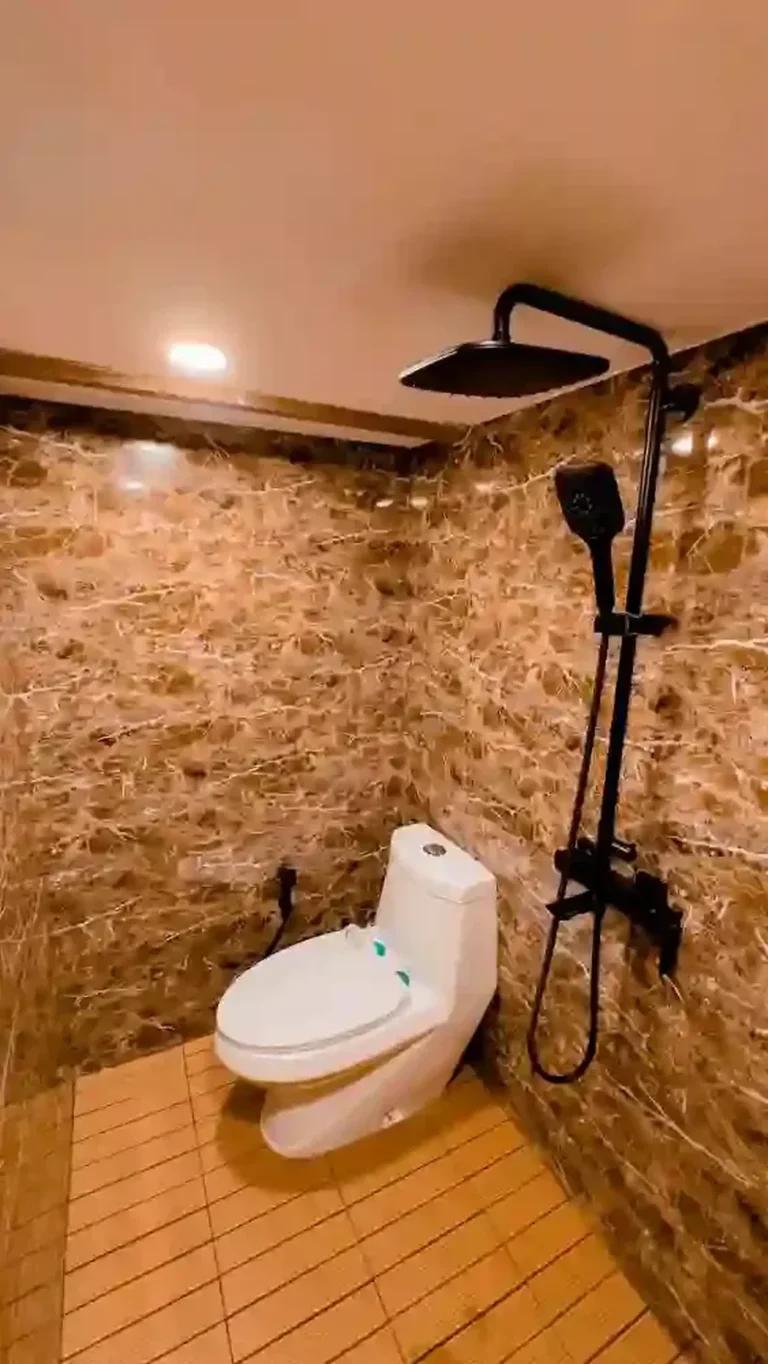 Stone-walled bathroom with rain shower and toilet in the Moon Suite of Semesta Voyages
