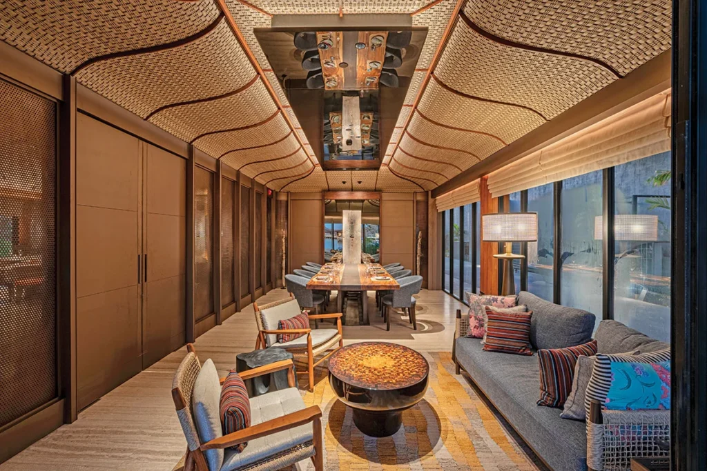 Lounge armchairs and a low round table under a curved timber ceiling at Umasa